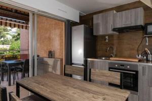 a kitchen with a wooden table and a counter top at Cozy duplexterrace barbecue pool beach on foot in Le Pradet +21 photos