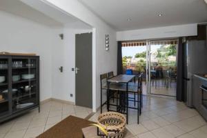 a kitchen with a table and chairs in a room at Cozy duplexterrace barbecue pool beach on foot in Le Pradet