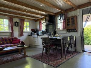 eine Küche mit Tisch, Stühlen und Sofa in der Unterkunft B&B Maarle in Poppel
