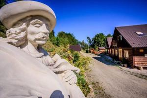 a statue next to a dirt road next to a building at Hubertówka Dom in Ujanowice