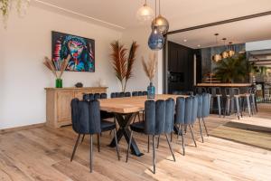 a dining room with a wooden table and blue chairs at Villa Signature Luxury & Exclusive seaside getaway in Le Grau-dʼAgde