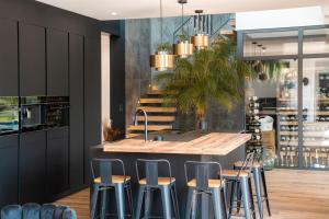 a kitchen with a sink and bar stools at Villa Signature Luxury & Exclusive seaside getaway in Le Grau-dʼAgde