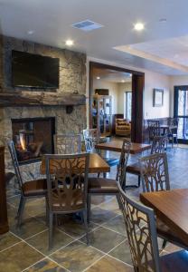 a restaurant with tables and chairs and a fireplace at Cedar Creek Lodge & Conference Center in Columbia Falls