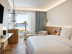a hotel room with a bed and a view of the ocean at Creta Palace, A Resort to Live in Rethymno