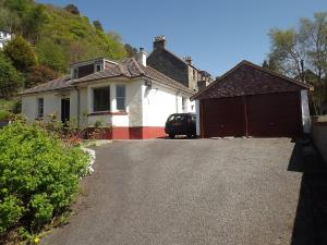 a car parked in front of a house with a garage at Glenavon Homestay in Oban