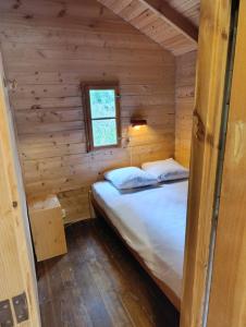 a bedroom with a bed in a wooden cabin at Saut du moine in Simiane-la-Rotonde