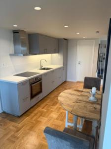 a kitchen with a wooden table and a wooden floor at Fisketången Seaside Stay in Kungshamn