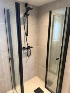 a shower stall with a glass door with a shower at Fisketången Seaside Stay in Kungshamn +4 photos