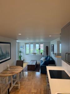 a living room with a table and a blue couch at Fisketången Seaside Stay in Kungshamn