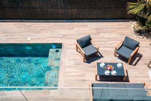 an overhead view of a pool with two chairs and a table at Villa Monégasque elegance & Exclusive seaside getaway in Sérignan