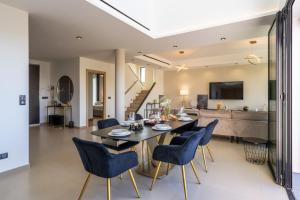 a dining room and living room with a table and chairs at Villa Monégasque elegance & Exclusive seaside getaway in Sérignan
