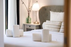 a bedroom with a white bed with a vase on a table at Villa Monégasque elegance & Exclusive seaside getaway in Sérignan