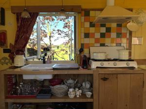 eine Küche mit einer Theke mit Fenster und einer Spüle in der Unterkunft B&B Maarle in Poppel