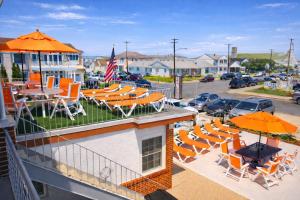 a balcony with chairs and tables and umbrellas at Sea Chest Motel in Wildwood Crest
