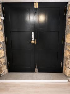 a black garage door with a stone wall at Posada Inés in Castro-Urdiales