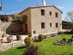una gran casa de piedra con un patio con césped en Casa Rural Torre Gargallo, en Morella
