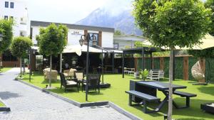 ein Restaurant mit Tischen und Stühlen auf einem grünen Rasen in der Unterkunft Three Points Hotel in Beldibi