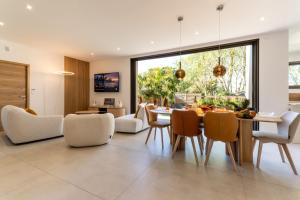a dining room and living room with a table and chairs at Villa Amphitrite Share beach & happiness in Le Grau-dʼAgde