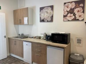 eine Küche mit Arbeitsfläche, Mikrowelle und Spüle in der Unterkunft Private 1st Floor Apartment - Perfect for Port of Dover, Eurotunnel and Short Stays in Dover
