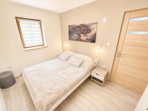 a small bedroom with a bed and a window at Zója Apartmanház in Nagykanizsa