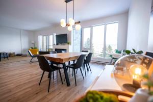a dining room and living room with a table and chairs at 210 - Chic Escape - View & Comfort with Pool in Baie-Saint-Paul +50 photos