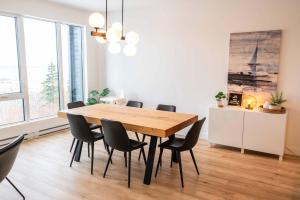 a dining room with a wooden table and chairs at 210 - Chic Escape - View & Comfort with Pool in Baie-Saint-Paul
