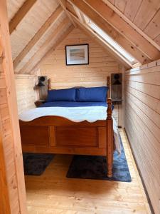 a bed in a room in a wooden cabin at Glenwood glamping pod in Morar