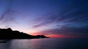 a sunset over a body of water with a mountain at Studio Maria Lenta in Lentas
