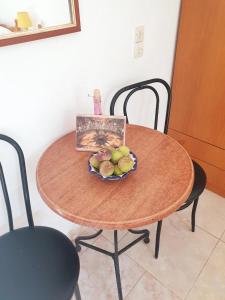 a wooden table with a bowl of fruit on it at Studio Maria Lenta in Lentas