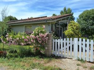 a small house with a white picket fence at Les Glycines de Soubize in Lablachère
