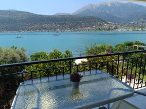 a glass table on a balcony with a view of a lake at Geni Bay 2 in Lefkada +19 photos