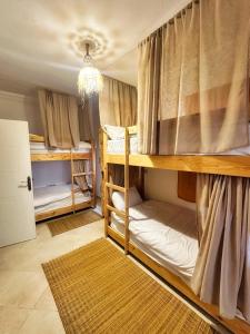 a room with two bunk beds and a chandelier at Surf and Tribe in Tamraght Ouzdar