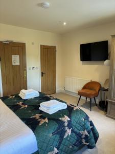 a hotel room with two beds and a flat screen tv at The Stag in Salhouse