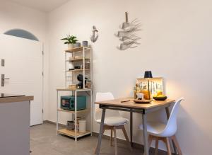 a kitchen with a table and two white chairs at Camera con Vista in Cervia