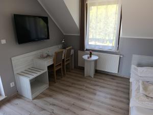 a living room with a table and a tv on the wall at Biovilla in Stobnicko