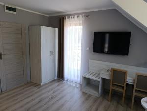 a living room with a table and a tv on the wall at Biovilla in Stobnicko