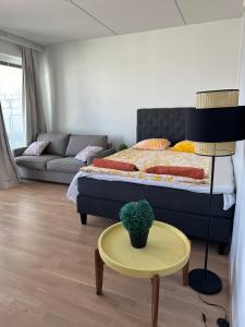 a bedroom with a bed and a table and a couch at Onnellinen Koti in Vaasa