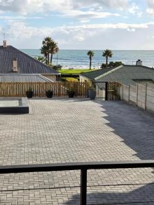 a patio with the ocean in the background at Charla on the Beach in Gordonʼs Bay