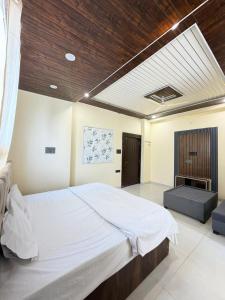a bedroom with a large white bed and a fireplace at Hotel Lotus Stay INN in Jabalpur