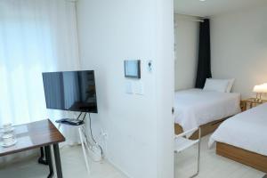 a small room with a bed and a television at Fresh Stay in Seoul