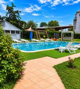 a swimming pool with lawn chairs and a swing at Hotel Venus in Venus