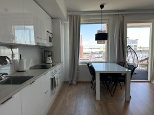 a kitchen with a table and a table and a dining room at Onnellinen Koti in Vaasa +8 photos