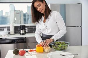 a woman standing in a kitchen preparing food at Hyatt House Dallas Uptown in Dallas
