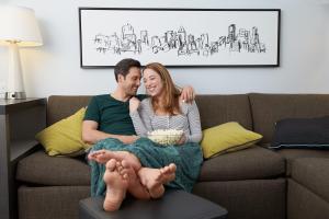 a man and woman sitting on a couch at Hyatt House Dallas Uptown in Dallas
