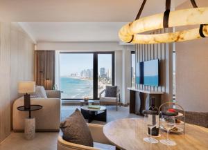 a living room with a view of the ocean at The Setai Tel Aviv, a Member of the leading hotels of the world in Tel Aviv
