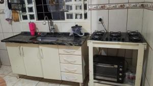 a small kitchen with a sink and a stove at Quarto casal standart max in Ribeirão Preto