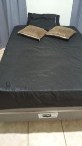 a bed with two pillows on top of it at Quarto casal standart max in Ribeirão Preto