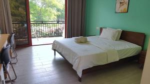ein Schlafzimmer mit einem großen Bett und einem Balkon in der Unterkunft M Y hotel in Dili