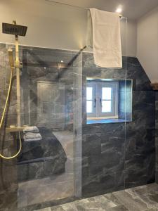 a bathroom with a glass shower with a window at The Stag in Salhouse +37 photos