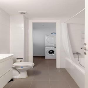 a bathroom with a toilet and a washing machine at Sea View Tower - 33rd Floor l Parking l Mamad in Bat Yam +39 photos
